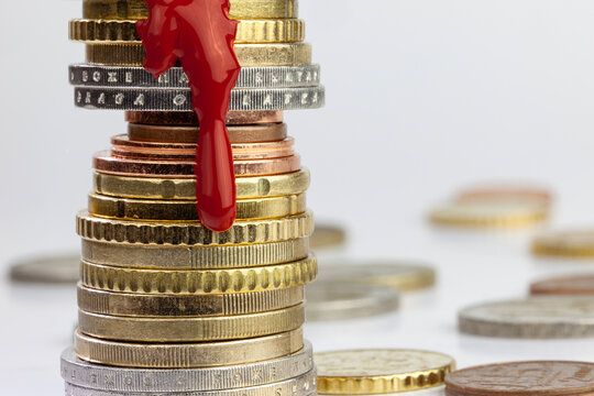 Blood like paint dripping on Euro cents stack