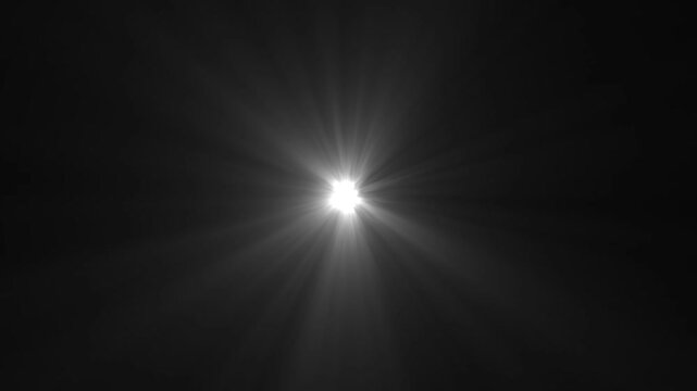 A bright white starburst lens flare effect emanating from the center of a dark black background creating a radiant glow with visible light rays and subtle atmospheric haze