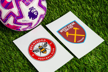 Fototapeta premium Brentford vs. West Ham United English Premier League matchup, team logos and football ball on green grass