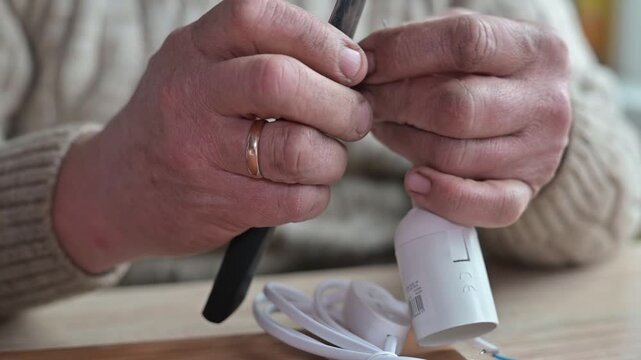 A person is engaged in the process of repairing a device, focusing on two different cables and connectors.