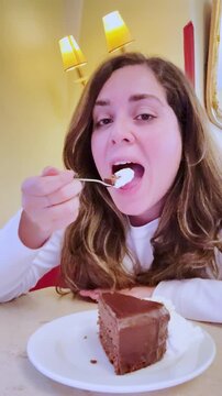 Influencer woman vlogging while eating chocolate cake