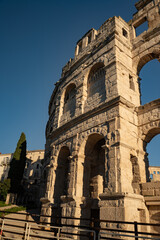 Close-up of ancient Roman stone arches of Pula Arena, historic limestone walls of the amphitheater in Istria, Croatia, architectural detail