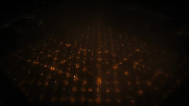 Aerial view of a city at night with a gridlike pattern of lights