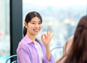 okサインを出す若い女性　ビジネス　オフィス