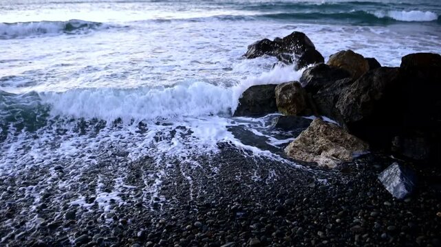 Close up of the Mediterranean Sea shoreline on Cyprus, with gentle waves lapping against the sandy beach. Sunlit water, detailed textures of sand and pebbles, and sparkling reflections captured in hig