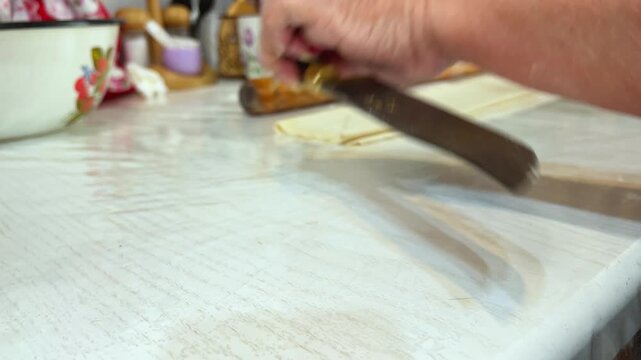 Close-up of woman cutting dough for festive manti
