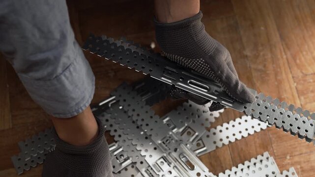 Female hands holding metal universal drywall brackets