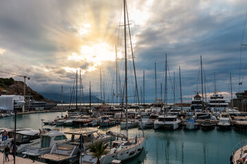 Small sea harbour with moored different yachts at sunset