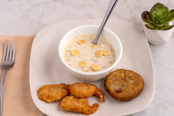 bowl of clam chowder with shrimp and crab cakes