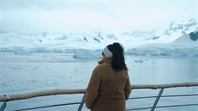 Girl On Expedition Cruise In Fleece Looking Out At Harsh Antarctica Landscape