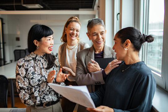 Diverse women colleagues celebrating success in modern office