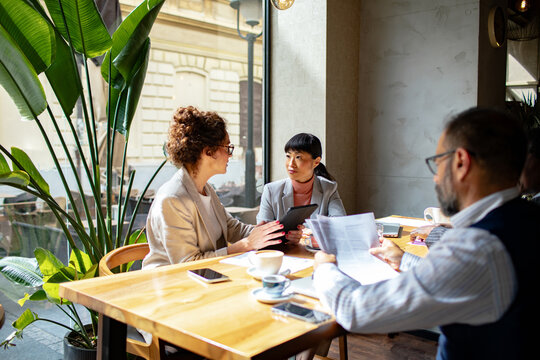 Business colleagues discussing strategy in urban cafe