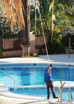 T&eacute;cnico de mantenimiento y socorrista de piscina con limpiafondos