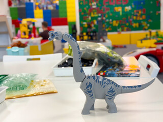 Naklejka premium Small gray brontosaurus toy in colorful playroom