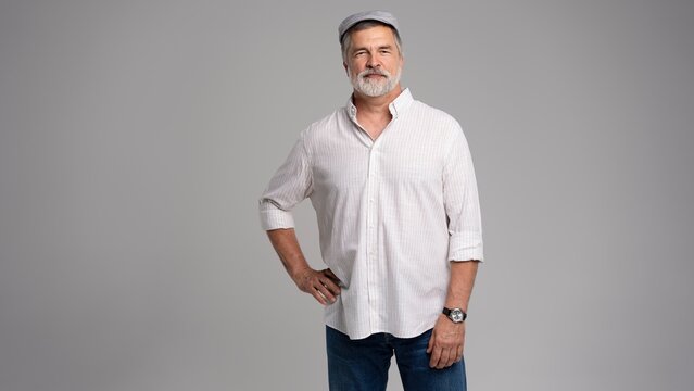 Friendly grey beard aged man in cap wear white shirt isolated on grey
