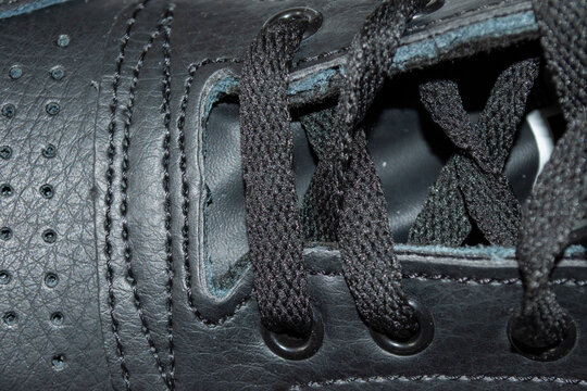 Detalle de cordones enlazados en zapatillas deportivas de color negro.