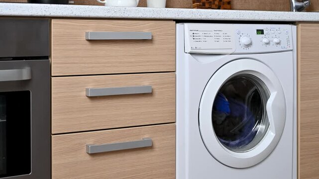Close-up of a built-in washing machine in a home kitchen.