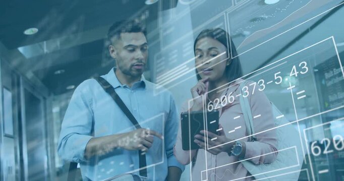 Man and woman examining tablet in tech corridor, showing floating charts and data