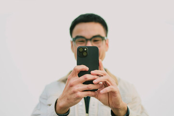 Fototapeta premium adult asian man using mobile, cell phone.portrait young male person posing smart phone smiling laughing look fun excited surprised happy.empty space for text advertising