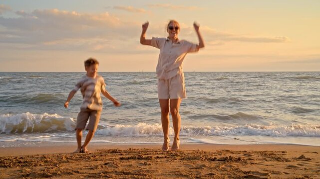 Family celebrates summer holidays by jumping on beach. High energy movement stimulates endorphins and promotes physical fitness in children and adults during travel. 