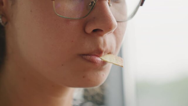 Multiracial woman guest hotel tasting closeup lips and chin culinary student tests texture and flavor with cracker subtle chew porcelain cup near mouth introspective profile soft window light sensory