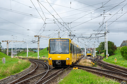 Modern Yellow SSB Tram Navigating Complex Rail Junction in Stuttgart, Germany