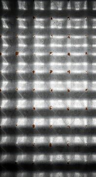 A detailed abstract background showing the repetitive pattern of corrugated zinc plating, emphasizing industrial texture and aged material, grit, iron, geometry