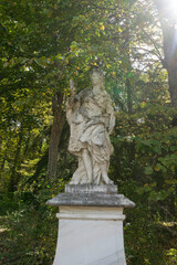 Statue surrounded by trees in a sunny setting.. Royal Palace of La Granja de San Ildefonso, Spain