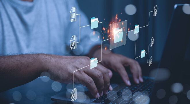 A businessman interacts with a futuristic document management system, DMS interface above a laptop.
