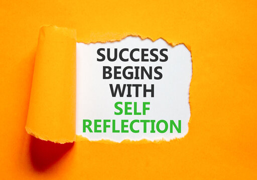 Self reflection symbol. Concept words Success begins with self reflection on beautiful white paper. Beautiful orange paper background. Business success begins with self reflection concept. Copy space.