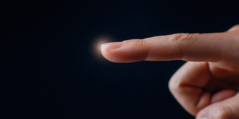 Close up image of human finger gently touching glowing point of light, symbolizing connection and interaction. dark background enhances focus finger and light, creating sense of wonder