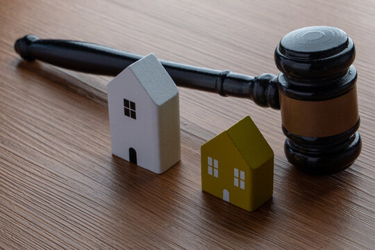 A gavel and two miniature wooden houses. Real estate law, property disputes, estate planning, divorce settlements, and housing market regulations concept.