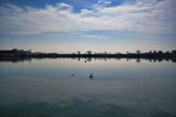 静かな水面に映る空と雲のリフレクション
