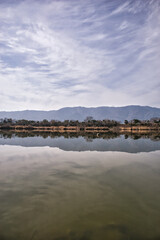 静かな水面に映る空と雲のリフレクション