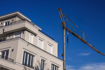 Neubau mit Baukran unter blauem Himmel