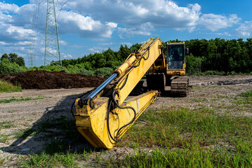 Yellow long reach excavator working on construction site
