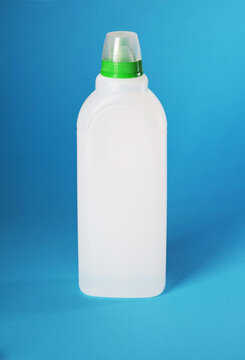 White plastic bottle with green and transparent cap for dishwashing machine rinse aid or salt solution product against blue background