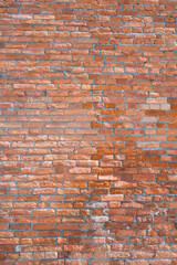 Naklejka premium Close-up of red brick wall texture for background. Modern loft interior with vintage brickwork surface. Vertical shot .