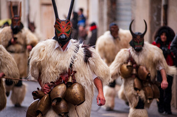 Traditional Boes masks from Ottana during Sardinian carnival parade, featuring horned wooden masks, sheepskin costumes and bells, representing ancient pastoral folklore traditions in Sardinia, Italy