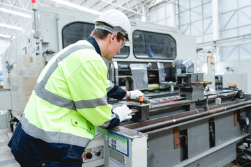 Caucasian industrial worker examining products moving on conveyor belt inside cardboard boxes paper...