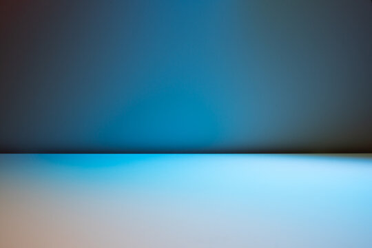 Smooth blue background for product presentation with sunlight and blurred shadows wall. Winter background.
