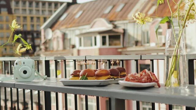 Snacks on the terrace of the cafe at the Sonia evening, catering of mini burgers on skewers, buffet table at the wedding. Plates with appetizers of meat, fruit, grapes, cheese and ham. Slow motion.