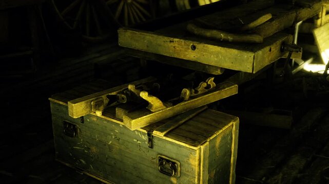 Open tool chest on wooden floor with scattered hand tools and hinged lid, gritty texture and low warm light, sense of pause in repair work and handson