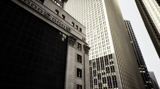 Philadelphia downtown skyscrapers towering in sunlight, glass and stone facades, upward perspective, sharp architectural lines and highcontrast urban energy