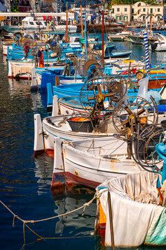 Colorful fishing boats in the harbor of Capri (Marina Grande, Italy). Summer atmosphere with sunny weather at a popular tourist destination, jet-set retreat, and dream location in the Mediterranean. 
