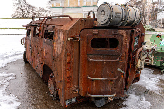 View of a heavily damaged, rust-covered military vehicle stands as a grim reminder amidst patches of melting snow, Kyiv, Kyiv, Ukraine.