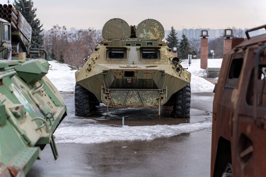 View of imposing military vehicles stand silent on a cold, wet ground, metal gleaming dully under the overcast sky, Kyiv, Kyiv, Ukraine.
