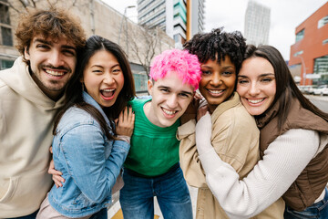 Obraz premium Young multiracial friends posing closely for group photo. Cheerful students enjoying time together outdoors. Youth community and unity concept.
