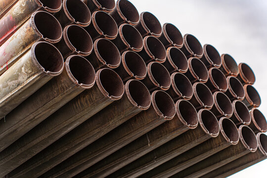 View of stacked rusted pipes with dark hollow centers create a mesmerizing pattern against a bright sky, Kyiv, Kyiv, Ukraine.