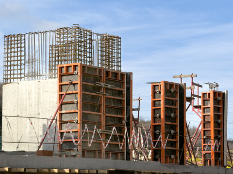 View of concrete pillars and rebar structures rise against a bright blue sky, marking construction's stark beauty in Sariyer, Istanbul, Turkey.